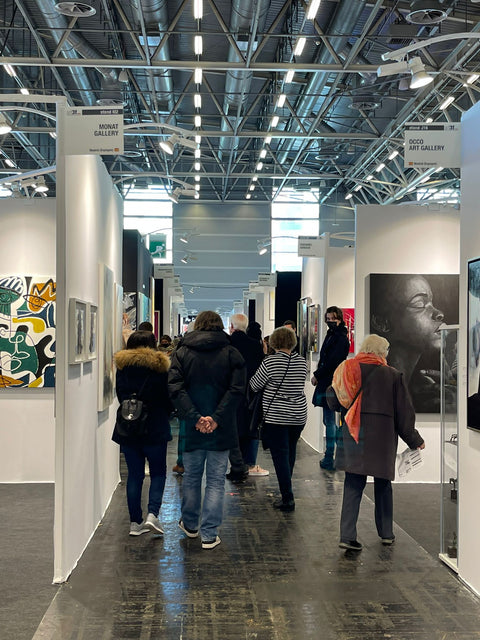 Besucher der Kunstausstellung zwischen den Booths.